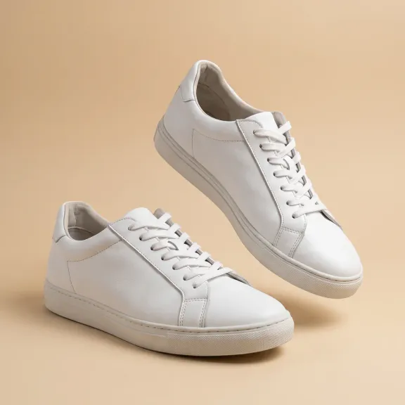 White sneakers on a sand background, a catalog shot from a phone photo, Nano Banana 2.1